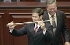 FILE - In this Sept. 13, 2005, file photo, then-Rep. Marco Rubio, R-Miami, left, holds a sword presented to him by then-Gov. Jeb Bush, right, during c