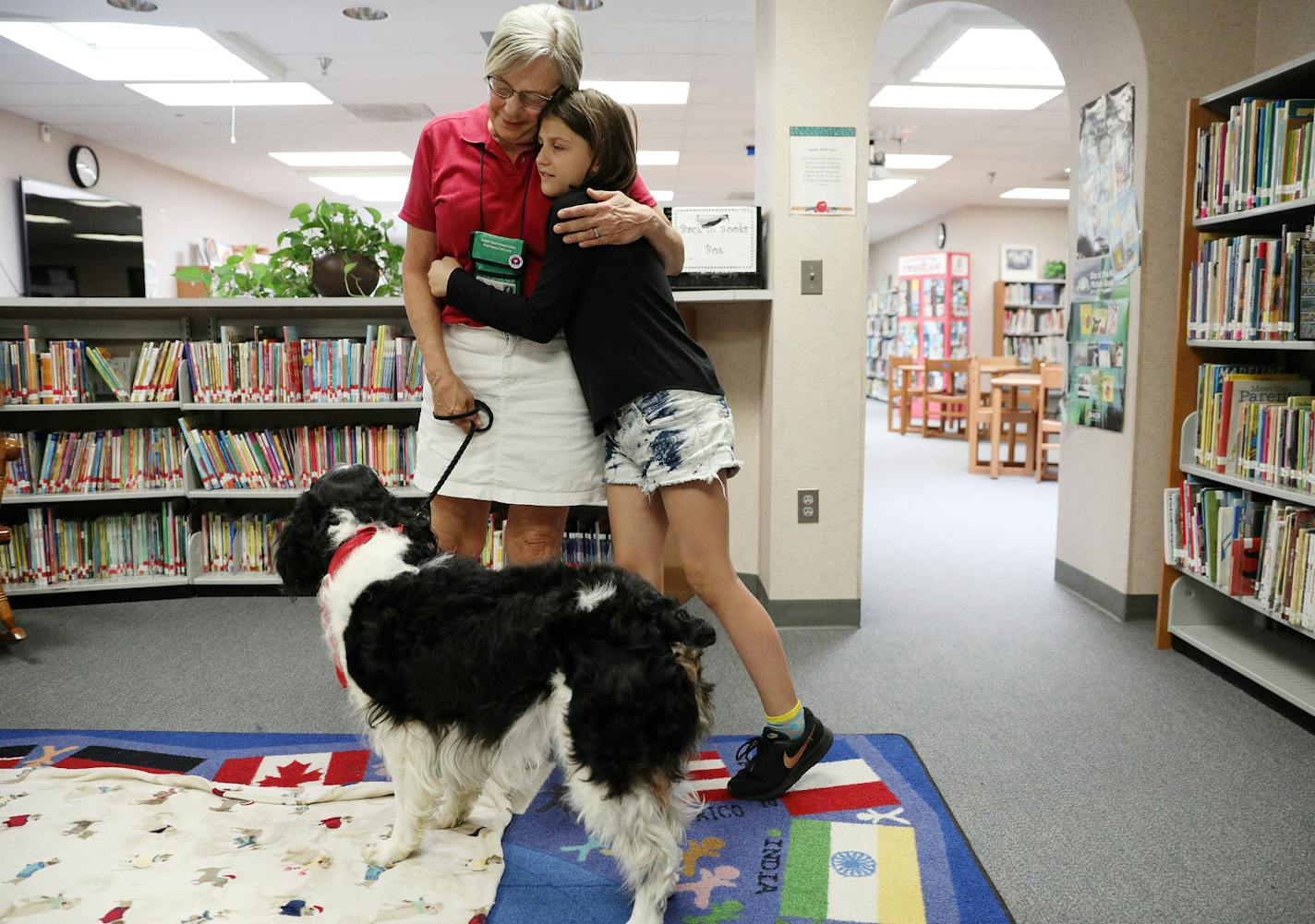 Jan Rempher and her therapy dog Arthur, a 5-year-old English Springer Spaniel, got hugs from Layla Larsen, 9, a fourth grader at Sioux Trail Elementary School after they read together Tuesday.] ANTHONY SOUFFLE &#xef; anthony.souffle@startribune.com Jan Rempher and her therapy dog Arthur, a 5-year-old English Springer Spaniel, read with students Tuesday, June, 5, 2018 at Sioux Trail Elementary School in Burnsville, Minn. Students struggling with reading say Arthur helps them to hone their skills