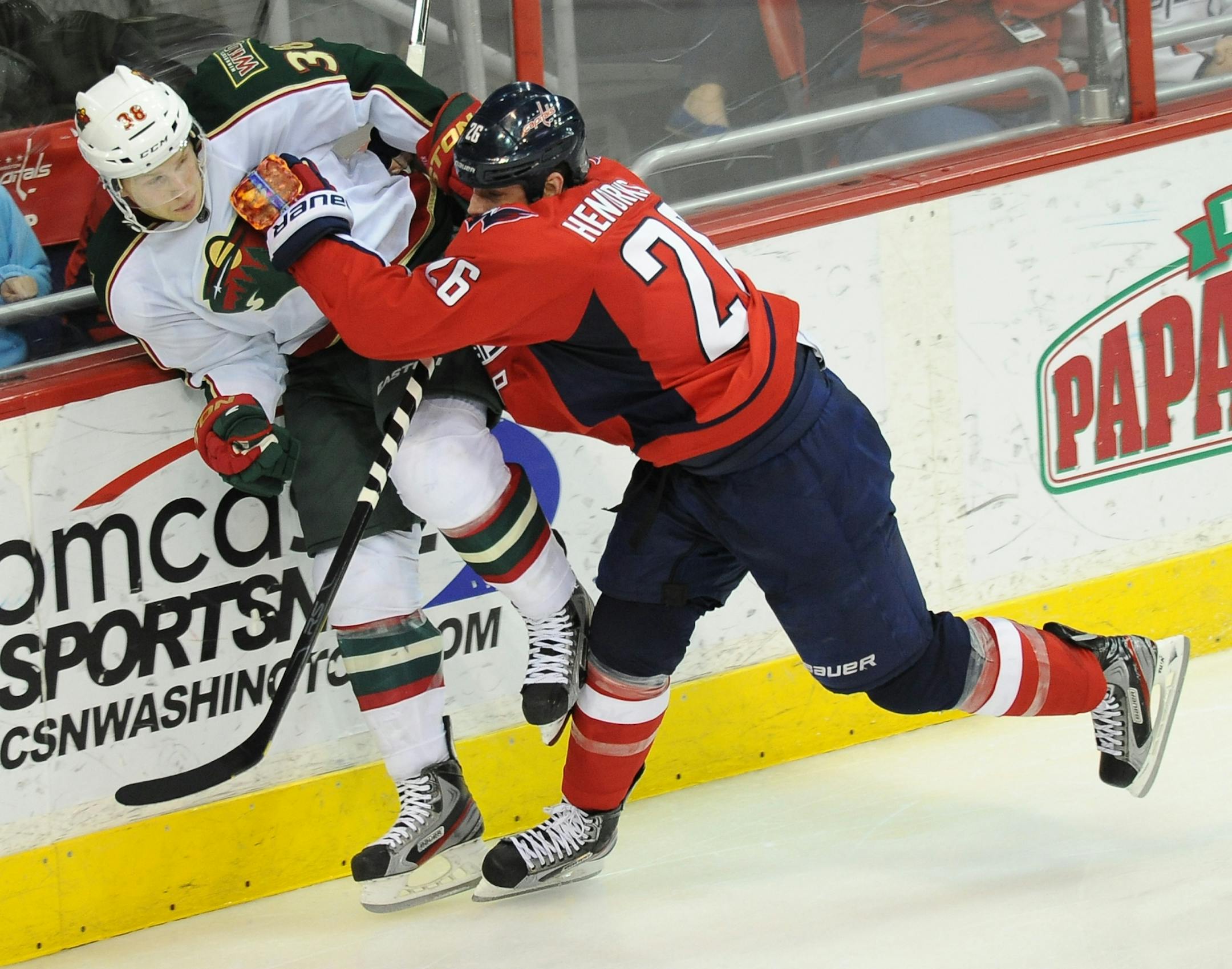 Washington Capitals left wing Matt Hendricks (26) drives Minnesota Wild defenseman Steve Kampfer (38) into the boards.