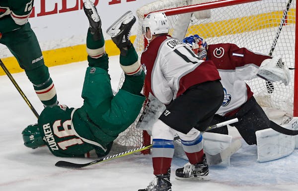 The Wild's Jason Zucker, left, tumbles to the ice over Colorado Avalanche goalie Semyon Varlamov in the first period Tuesday.
