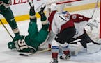 The Wild's Jason Zucker, left, tumbles to the ice over Colorado Avalanche goalie Semyon Varlamov in the first period Tuesday.