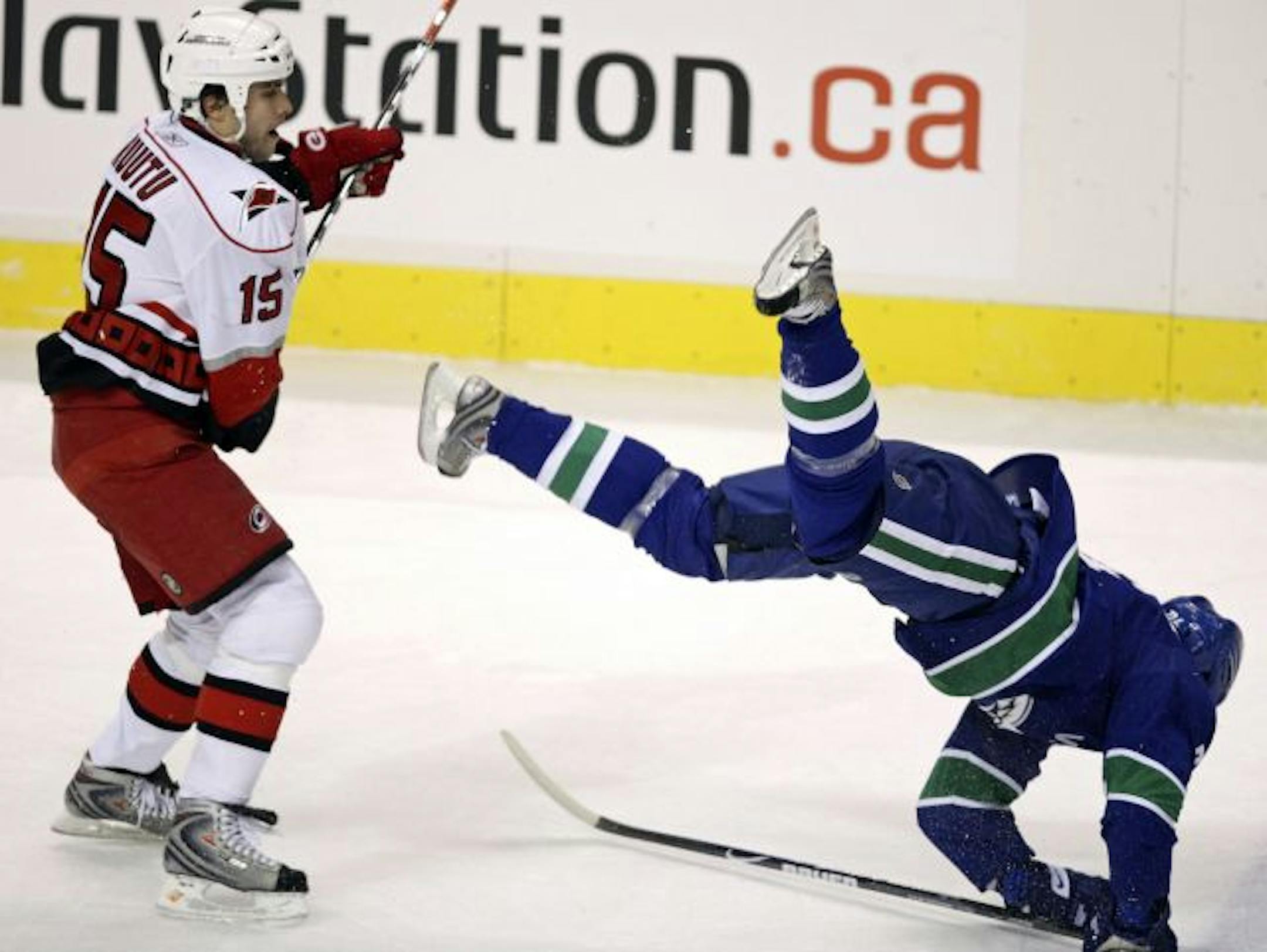 Carolina Hurricanes' Tuomo Ruutu, left, of Finland, checks Vancouver Canucks' Darcy Hordichuk to the ice during the first period of an NHL hockey game in Vancouver, British Columbia on Tuesday, Feb. 3, 2009.