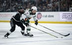 Wild defenseman Brock Faber fights off Kings winger Adrian Kempe to control the puck during Monday night's game in Los Angeles.