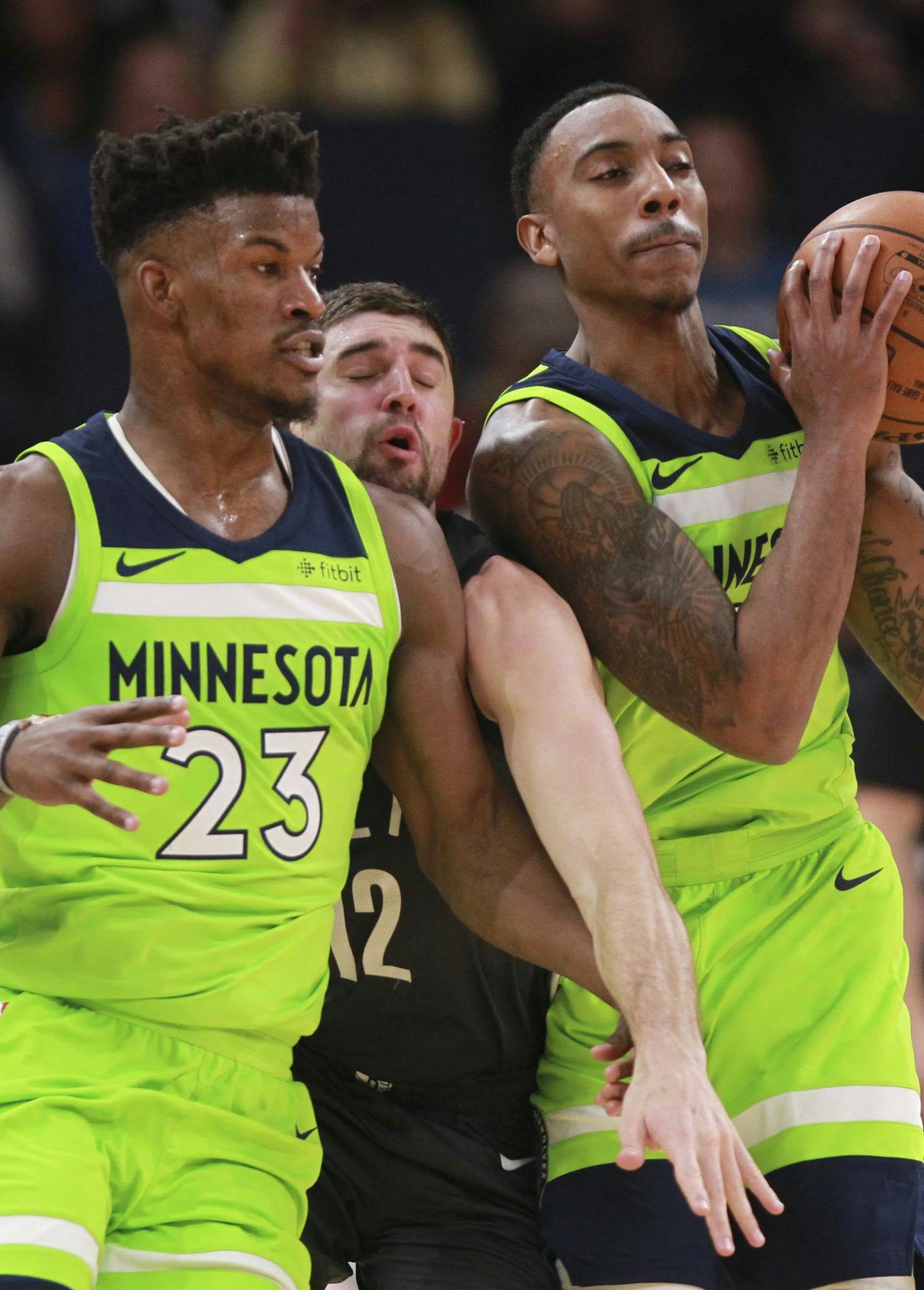 Brooklyn Nets guard Joe Harris (12) tries to break up a handoff by Minnesota Timberwolves guard Jeff Teague (0) and Minnesota Timberwolves guard Jimmy Butler (23) in the first quarter of an NBA basketball game Saturday, Jan. 27, 2018, in Minneapolis. (AP Photo/Andy Clayton-King)