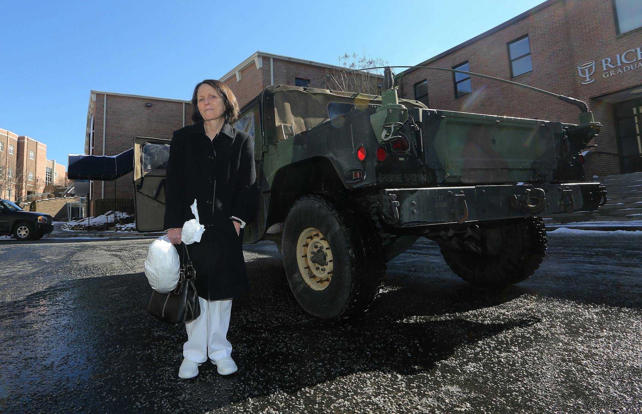 Lila Gunter waits next to a Georgia National Guard vehicle before they take her to pick up her car after it was towed in the winter storm that swept across the state Thursday, Jan. 30, 2014, in Atlanta.