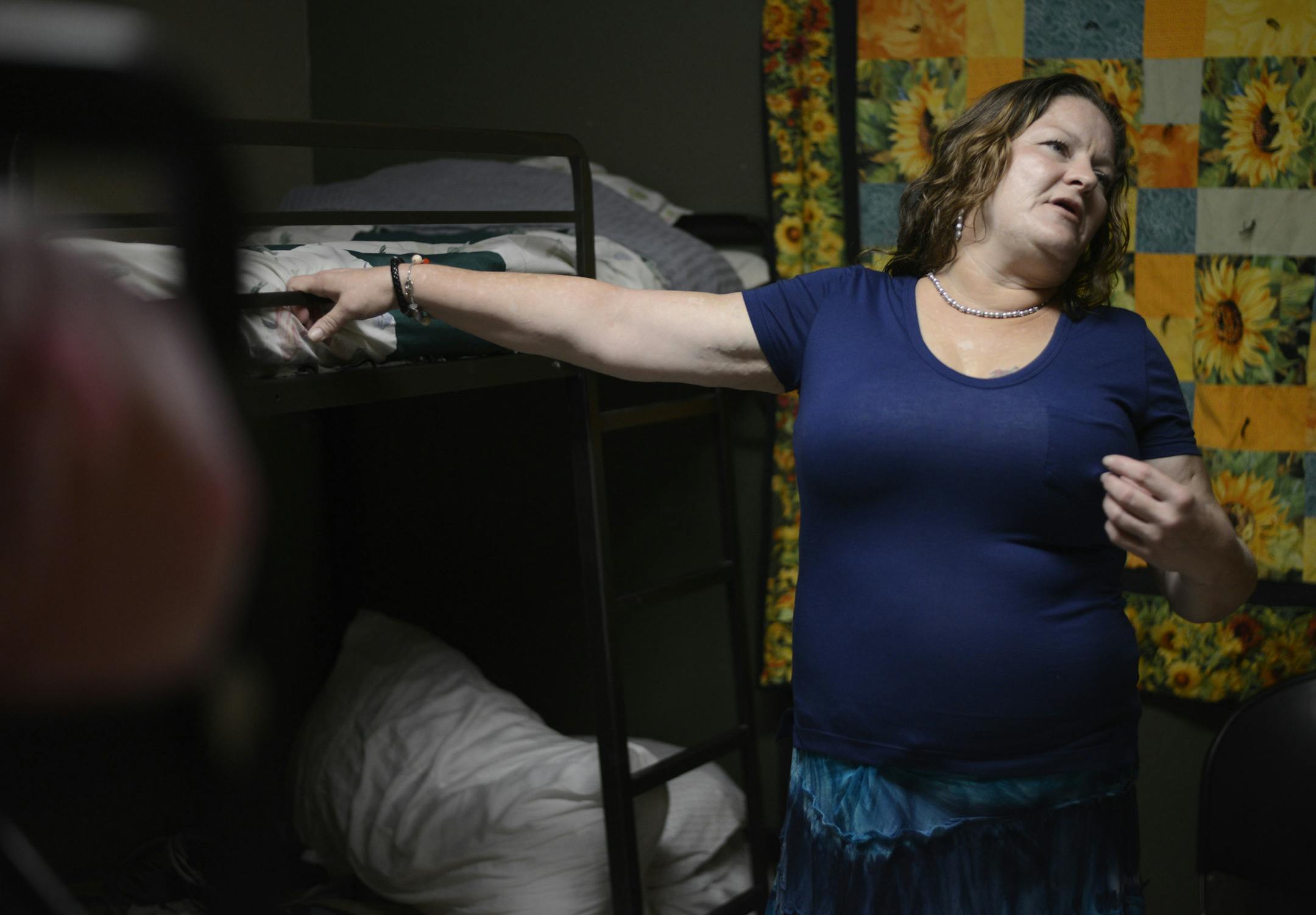 Domestic violence survivor Susan Contreras talks about her abuse as she stands by her bed in a Phoenix-area shelter for victims of domestic violence on Wednesday, Aug. 3, 2016. Contreras is part of a unique program at the Barrow Neurological Institute in Phoenix that aims to assist abuse survivors who have suffered head trauma. (AP Photo/Beatriz Costa-Lima)