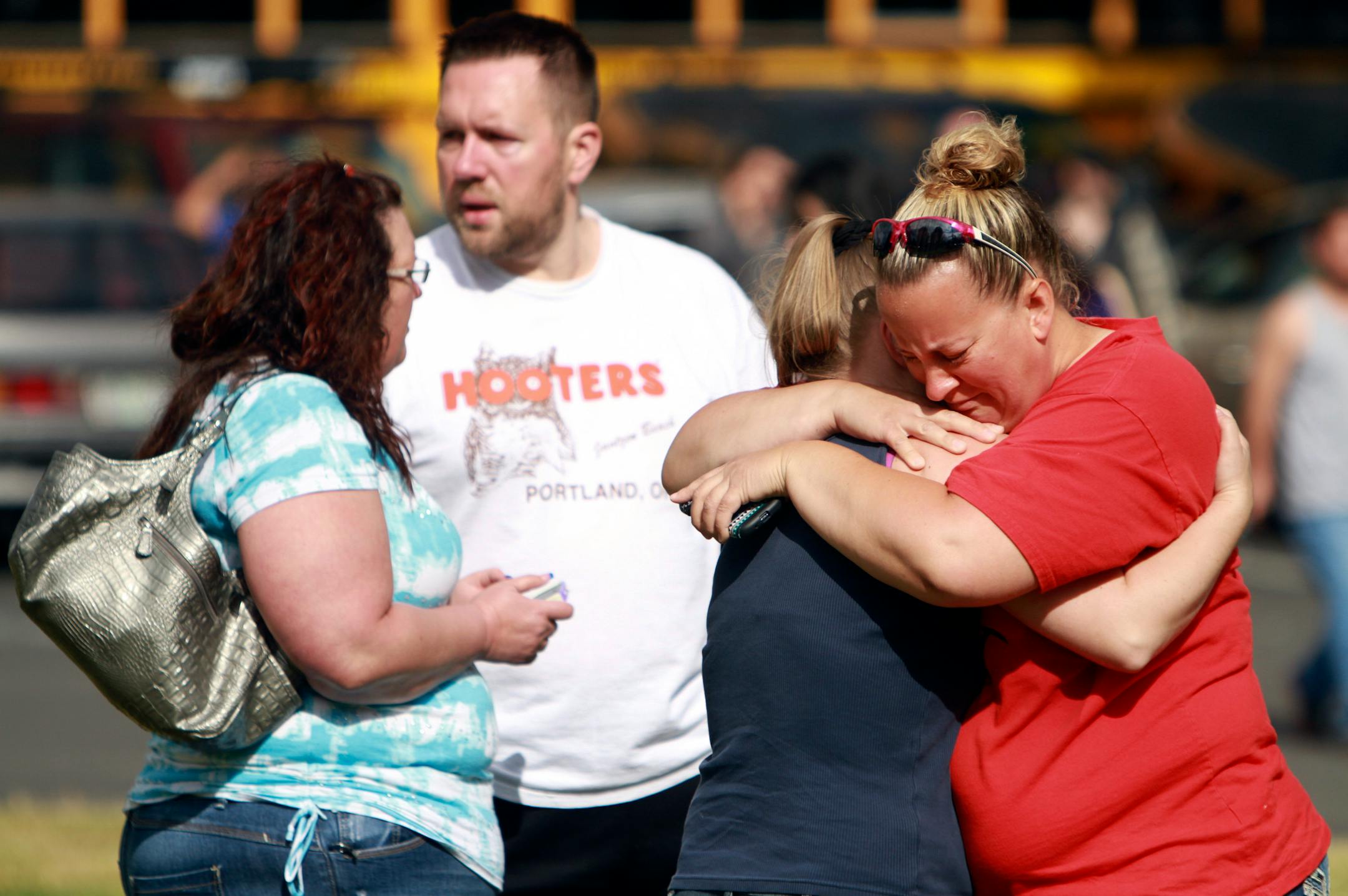 People comfort eachother as they await hear about the safety of students after a shooting at Reynolds High School Tuesday, June 10, 2014, in Troutdale, Ore. A gunman killed a student at the high school east of Portland Tuesday and the shooter is also dead, police said. (AP Photo/The Oregonian, Faith Cathcart) MAGS OUT; TV OUT; LOCAL TV OUT; LOCAL INTERNET OUT; THE MERCURY OUT; WILLAMETTE WEEK OUT; PAMPLIN MEDIA GROUP OUT