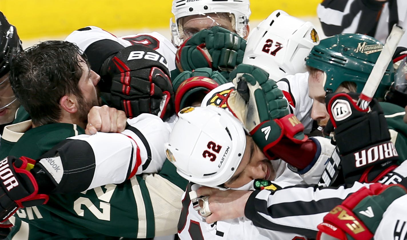 Referees and teammates tried to separate Cal Clutterbuck (22) and Johnny Oduya (27) in the second period. ] CARLOS GNZALEZ cgonzalez@startribune.com May 5, 2013, St. Paul, Minn., Xcel Energy Center, NHL Stanley Cup Playoffs, quarterfinals, Minnesota Wild vs. Chicago Blackhawks