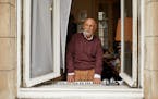 Simon Gronowski, a Holocaust survivor, at the electric piano he moved beneath a window of his apartment at the height of the first wave of the coronav