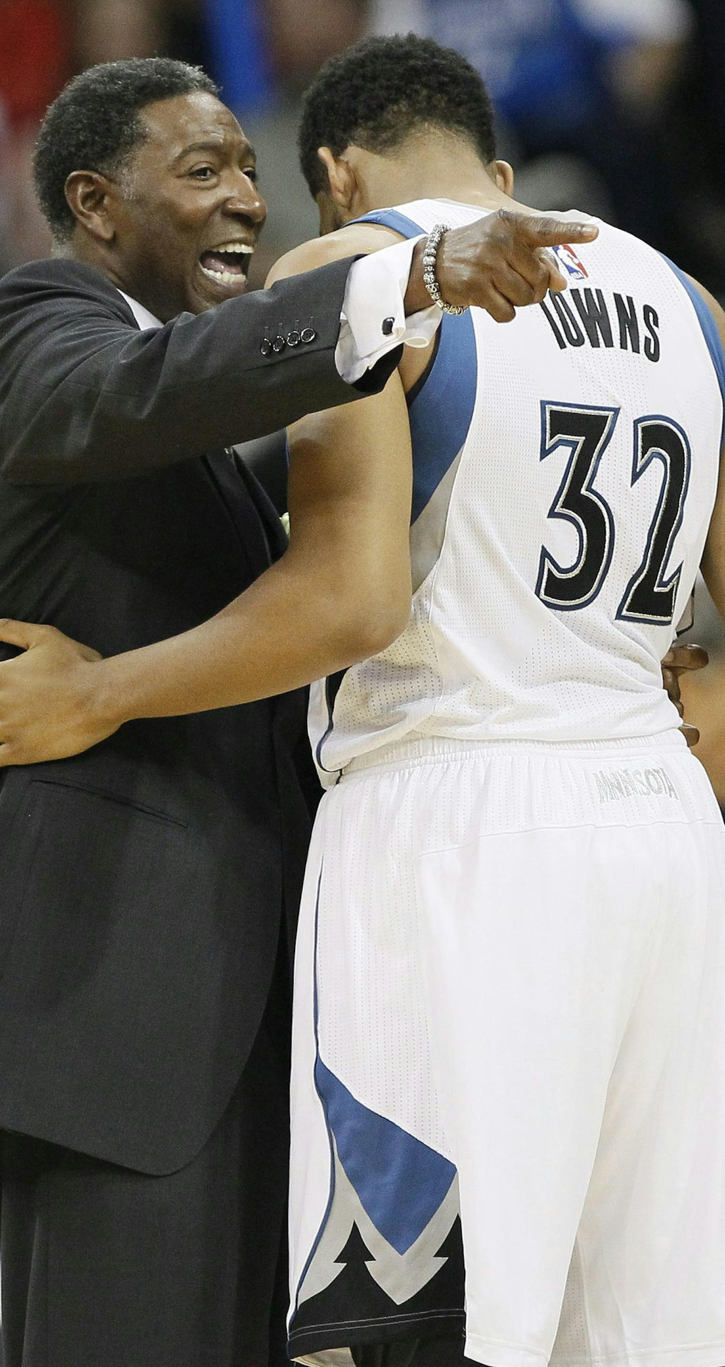 Minnesota Timberwolves' interim coach Sam Mitchell, left, talks to Karl-Anthony Towns (32) during the first half of an NBA preseason basketball game, Saturday, Oct. 10, 2015, in Winnipeg, Manitoba. (John Woods/The Canadian Press via AP) MANDATORY CREDIT ORG XMIT: JGW121