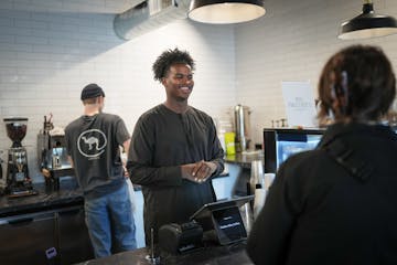 Hamze Jama, a former member of a Futsal Society team, served customers at Fawkes Alley Coffee, where he works and receives mentoring.