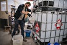 Steven Sola, the processing director at Vikre Distillery, measured out alcohol to be mixed and denatured into sprayable hand sanitizer on Tuesday. ]
A