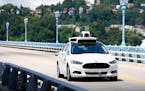 FILE - In this Thursday, Aug. 18, 2016, file photo, Uber employees test a self-driving Ford Fusion hybrid car, in Pittsburgh. After taking millions of
