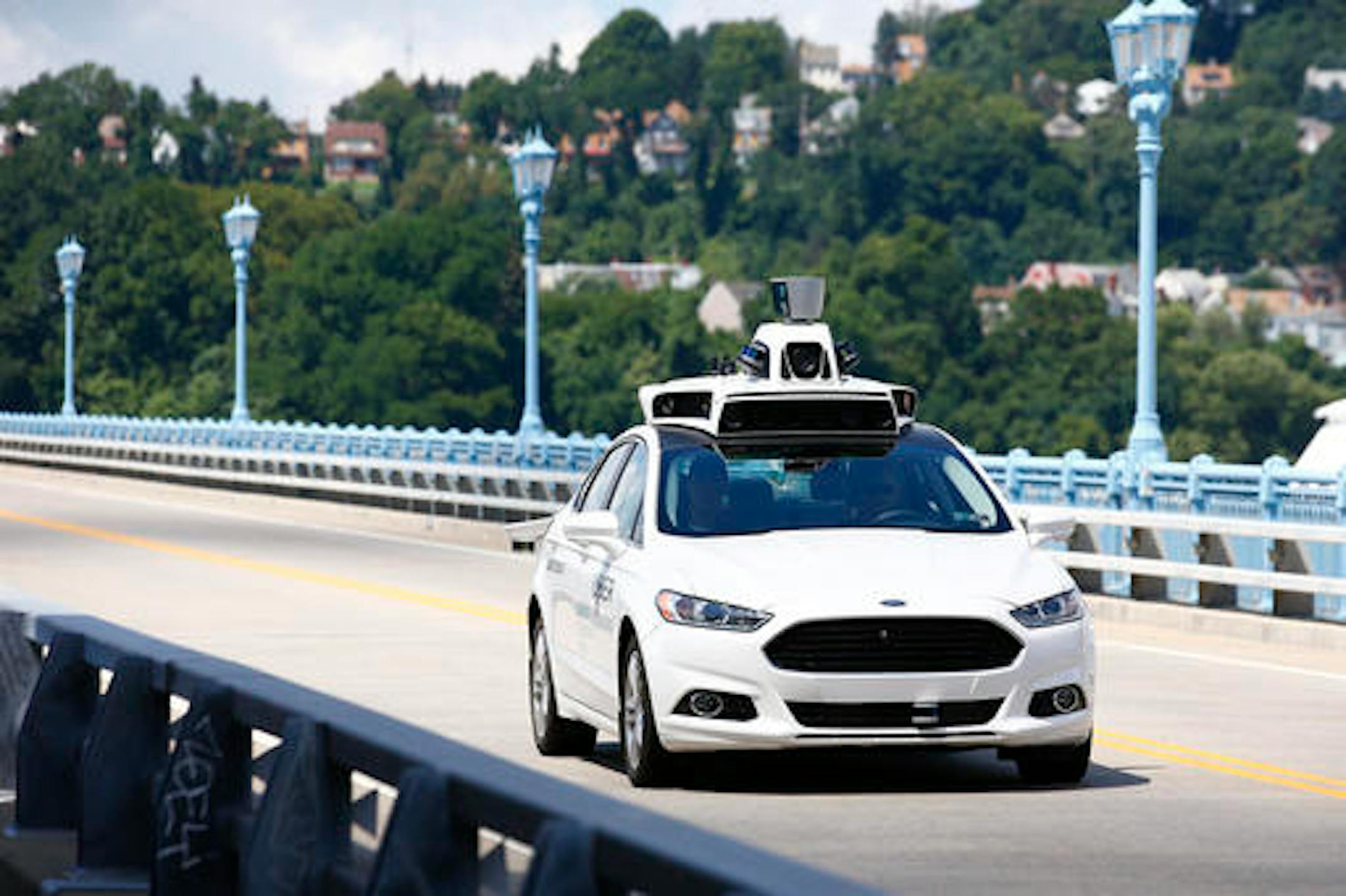 FILE - In this Thursday, Aug. 18, 2016, file photo, Uber employees test a self-driving Ford Fusion hybrid car, in Pittsburgh. After taking millions of factory jobs, robots could be coming for a new class of worker: people who drive for a living. (AP Photo/Jared Wickerham, File)