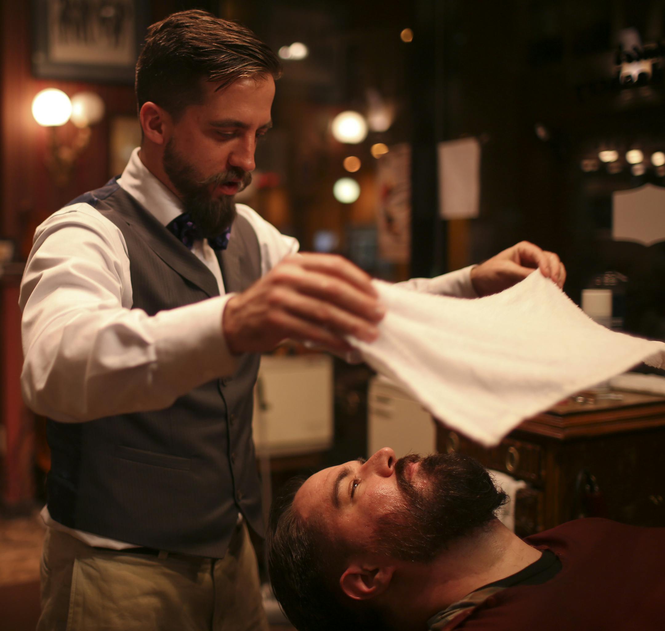 Steve Carlin of Crystal has a full beard, but allowed Nick Steeves, a barber at Heimie's Haberdashery in downtown St. Paul, to trim it back and offer some grooming tips along with a haircut Wednesday night, November 6, 2013. Barber Nick Steeves got ready to apply the second hot towel to Steve Carlin's face as part of his beard trim. ] JEFF WHEELER &#x201a;&#xc4;&#xa2; jeff.wheeler@startribune.com
