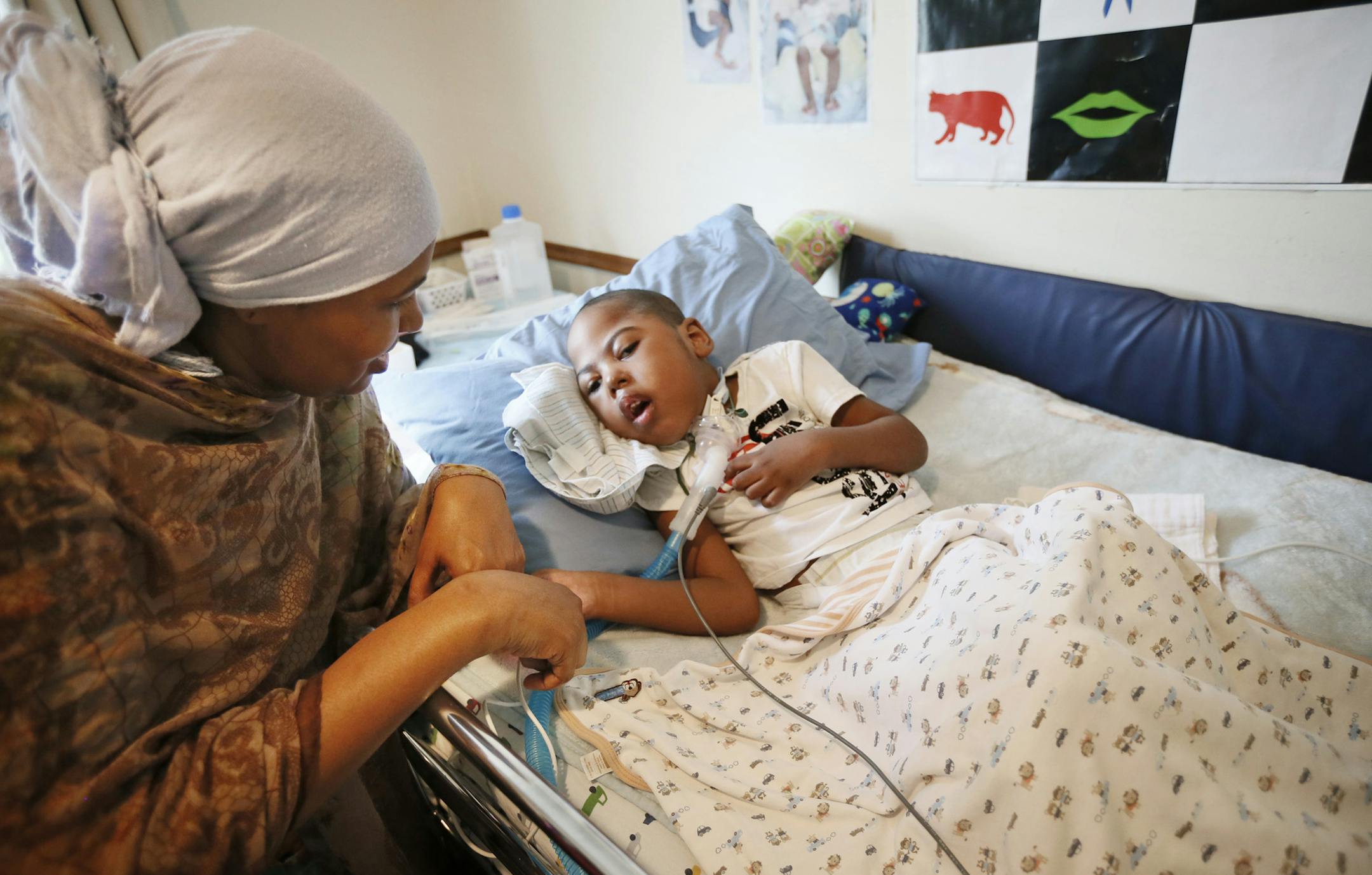 Fardosa Ibrahim rubbed her 4-year-old son Khalid hand as he rested in his bed. Fardosa is a educated nurse from Dubai and originally from Somalia, and son has cerebral palsy. She is try to help educated other members of the Somali community on how to seek help with their children with disabilities . ] JERRY HOLT ‚Ä¢ jerry.holt@startribune.com