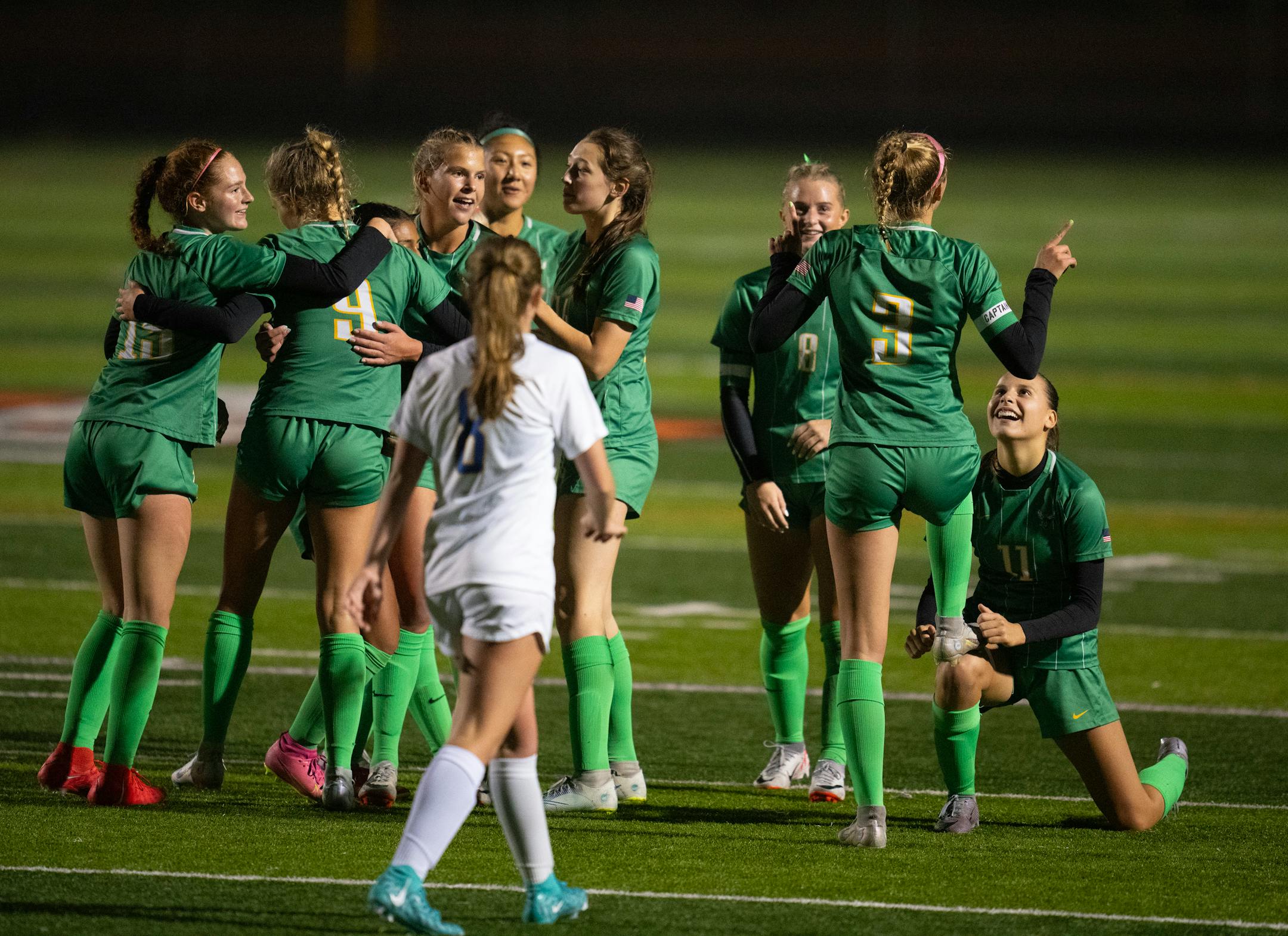 Edina's Izzy Engle (3) celebrated with a shoe shine from Lou Ruffien after she scored the second goal of her hat trick in the second half.