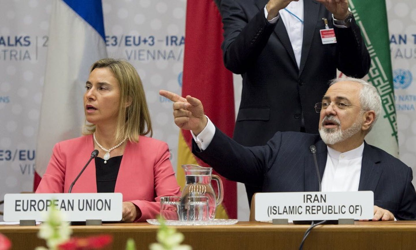 Iranian Foreign Minister Mohammad Javad Zarif, right, sits next to European Union High Representative Federica Mogherini during a plenary session at the United Nations building in Vienna, Austria July 14, 2015. After 18 days of intense and often fractious negotiation, diplomats Tuesday declared that world powers and Iran had struck a landmark deal to curb Iran's nuclear program in exchange for billions of dollars in relief from international sanctions, an agreement designed to avert the threat o