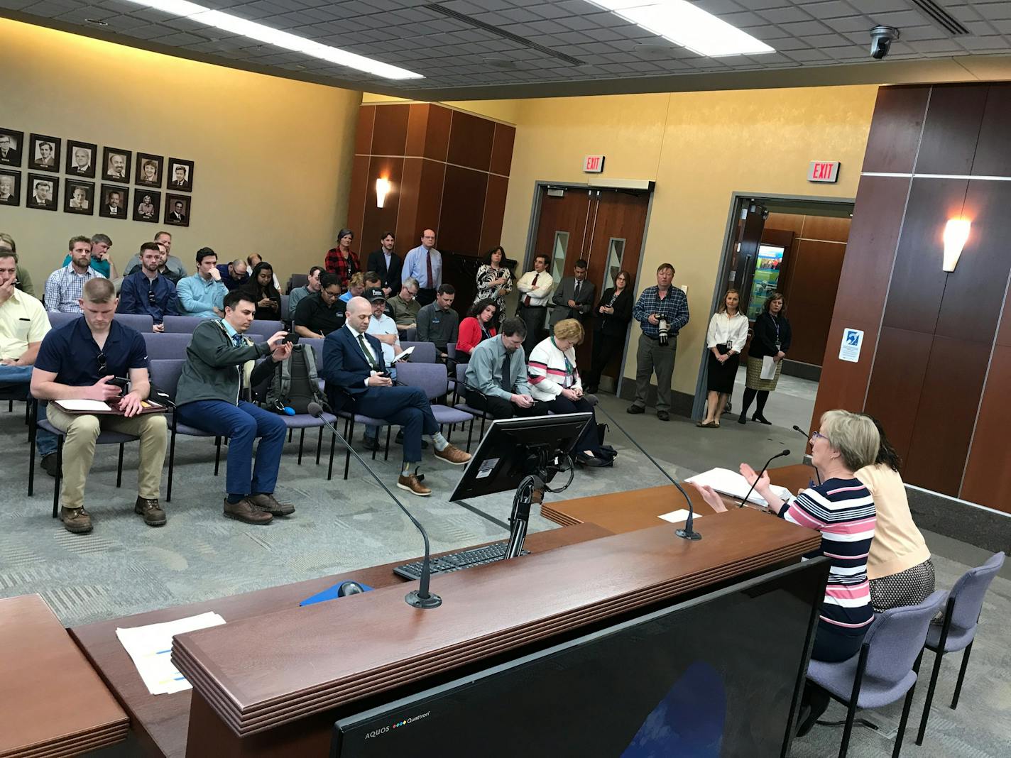 Metropolitan Council staffer Aubern Dees prepares to read the new bid amounts to a crowd at the Met Council chambers on Thursday.