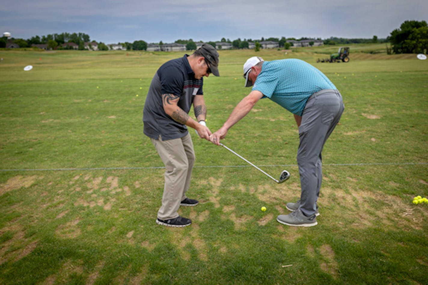 Golf Pro John Kellin helps war veteran Geno Mucciacciaro, cq, with his golf swing as they participate in a day of PGA Hope lessons at Chaska Town Course in Chaska, Minn., on Wednesday, July 6, 2022.&nbsp;Mucciacciaro is an Army Combat Veteran who was wounded during Operation Enduring Freedom.&nbsp;] Elizabeth Flores • liz.flores@startribune.com