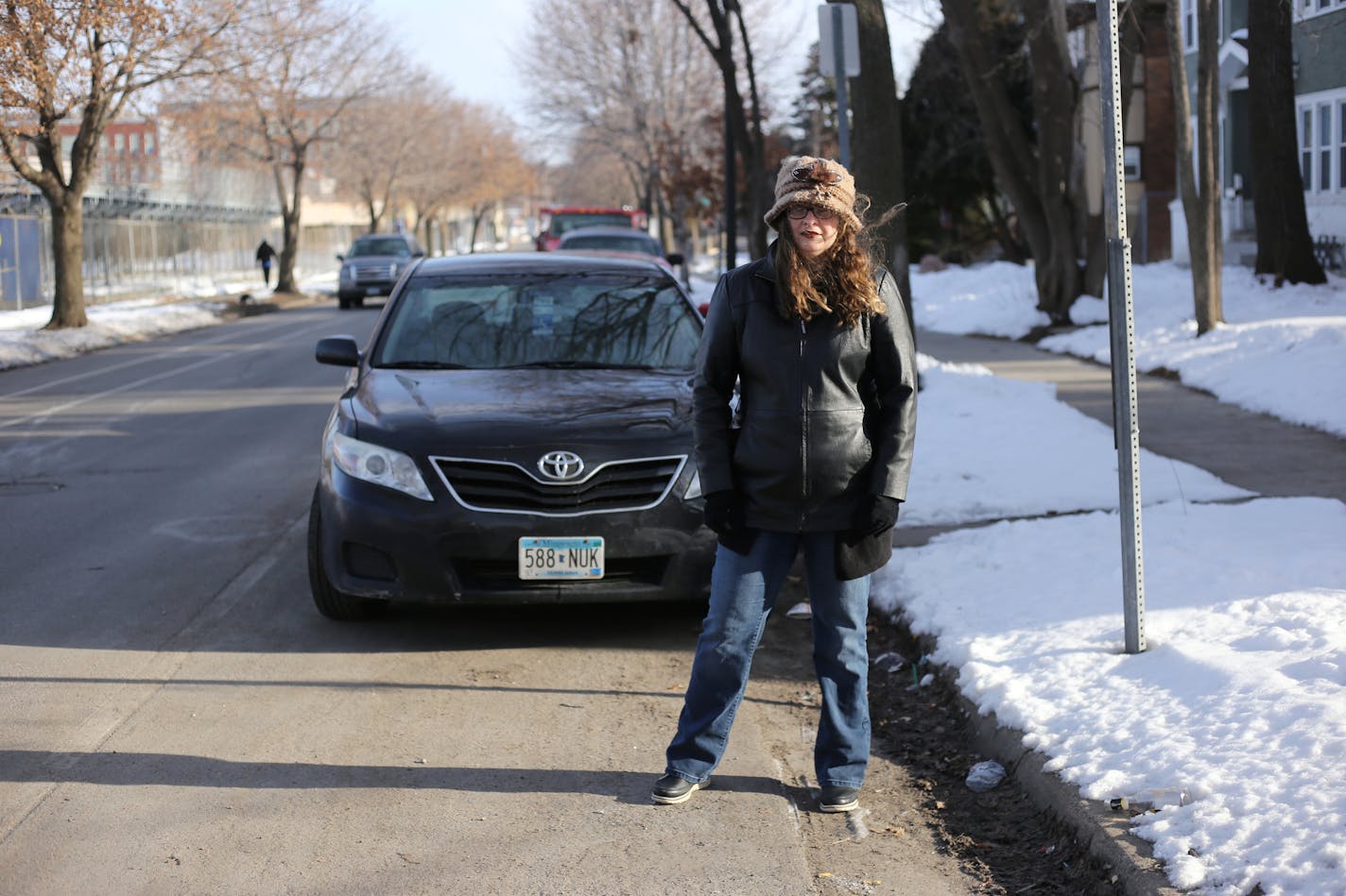 Patricia Fox stands by her vehicle, which is parked in a designated disability parking spot, in front of her Fremont Avenue home in North Minneapolis on Friday, April 6, 2018. Fremont Avenue and neighboring Emerson Avenue will undergo bike lane changes, causing Fox's and five other disabled individuals' parking spots to move further from their homes. [Ellen Schmidt &#x2022; ellen.schmidt@startribune.com