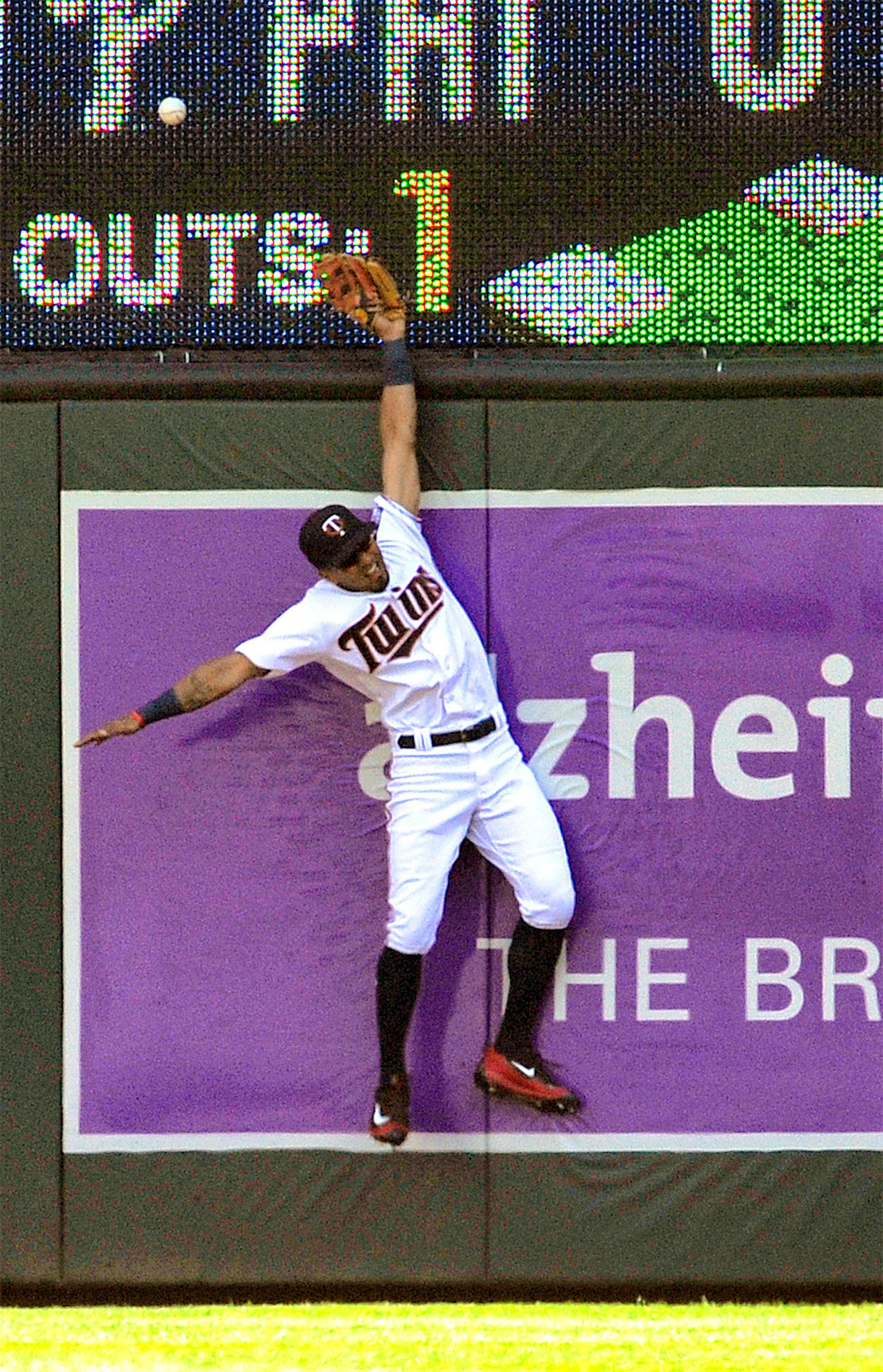 Minnesota Twins center fielder Eddie Rosario tries for a triple off the wall by Kansas City Royals' Paulo Orlando in the first inning of a baseball game, Sunday, Aug. 14, 2016, in Minneapolis.