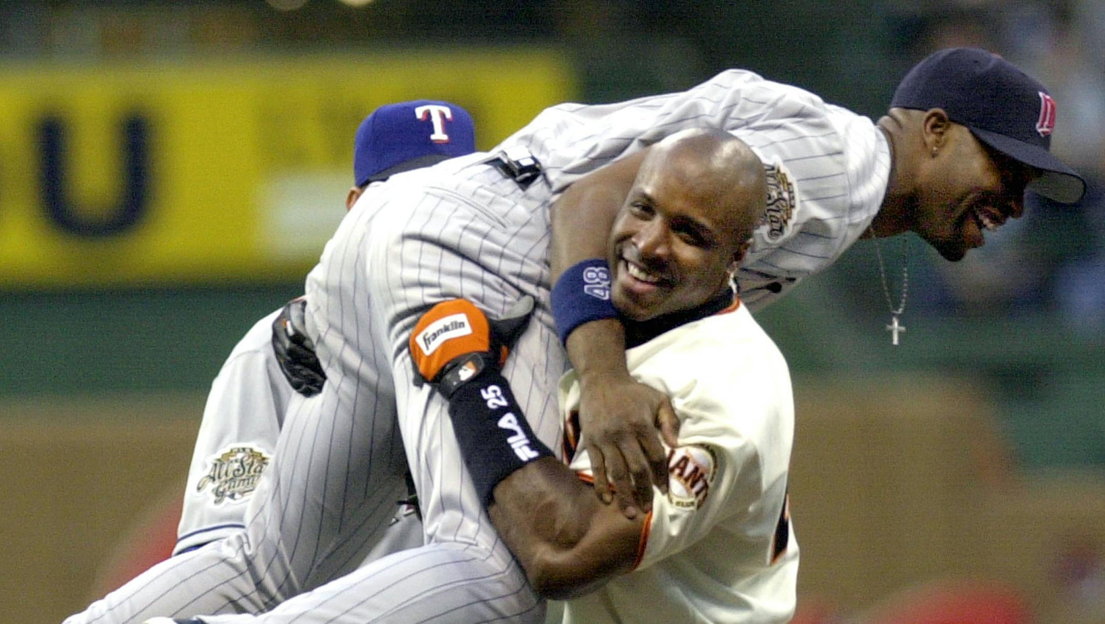 National League All-Star Barry Bonds of the San Francisco Giants playfully picks up American League All-Star Torii Hunter of the Minnesota Twins after Hunter caught robbed Bonds of a home run in the first inning of the All-Star Game in Milwaukee, Tuesday, July 9, 2002. (AP Photo/Ann Heisenfelt) ORG XMIT: ASG129 ORG XMIT: MIN1407011516106165