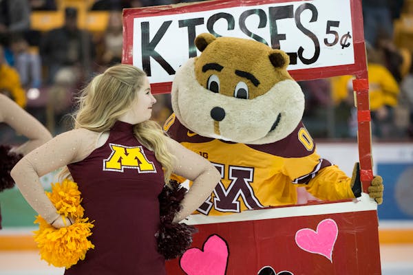 Goldy the Gopher tries to get a kiss from a cheerleader before the third period of Saturday night's game at Mariucci Arena. ] (Aaron Lavinsky | StarTr