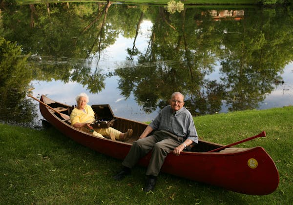 Harry and Dee Mixer pose in their canoe on a pond near their Golden Valley home. Dee is cradling the same wind-up phonograph that Harry brought along 