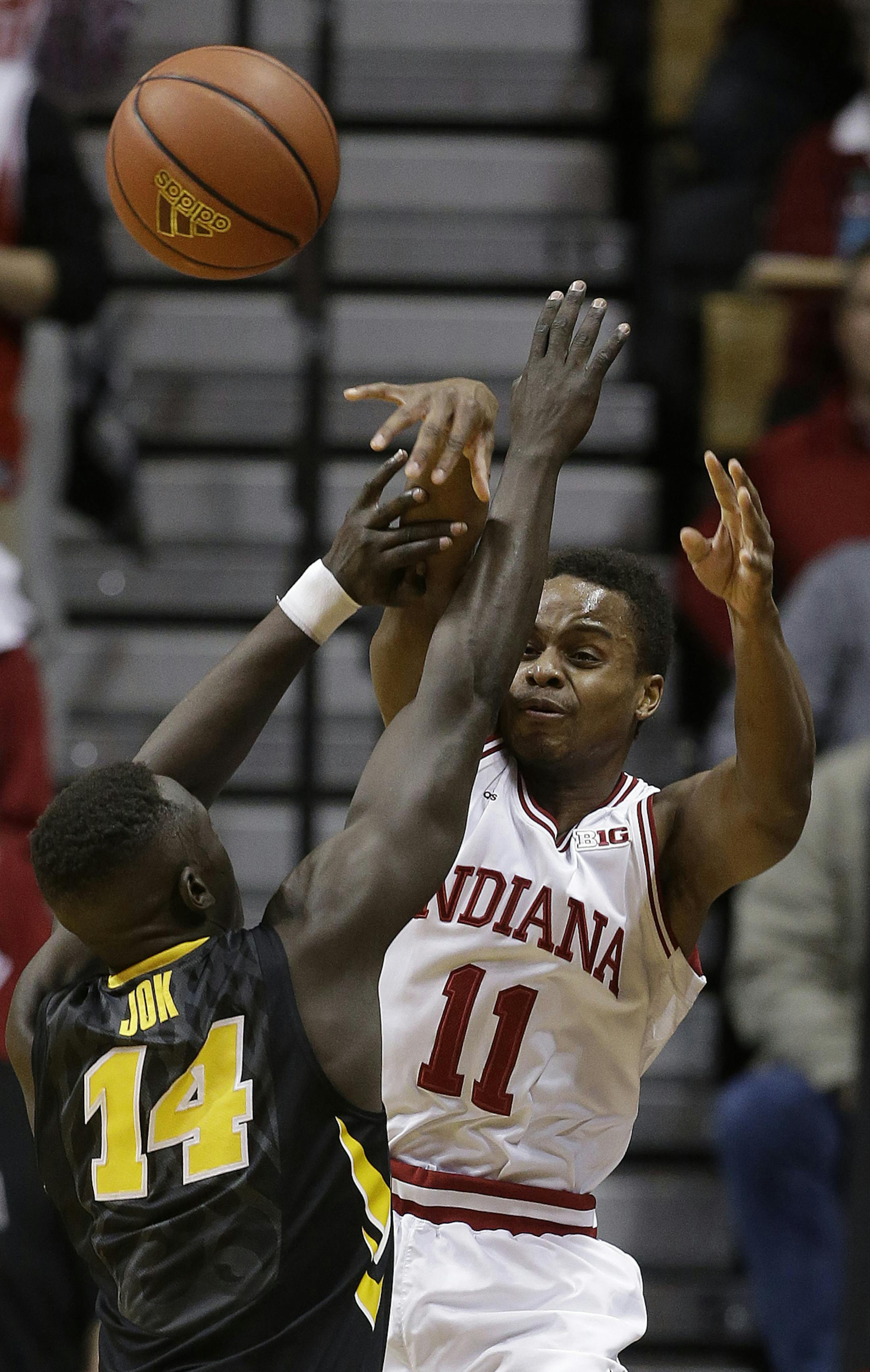 Indiana's Yogi Ferrell (11) passes over Iowa's Peter Jok (14) during the first half of an NCAA college basketball game Thursday, Feb. 11, 2016, in Bloomington, Ind. (AP Photo/Darron Cummings)