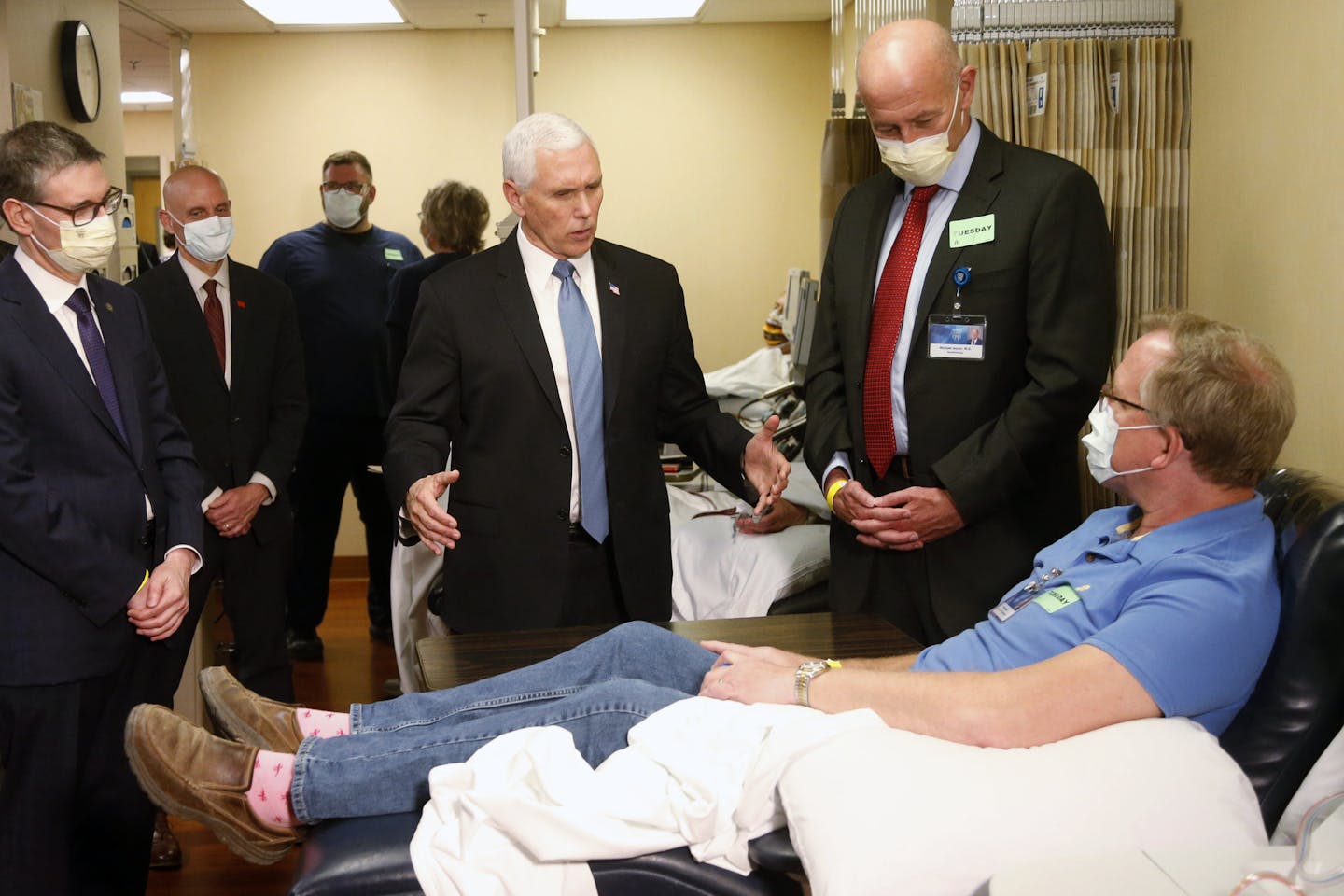 Vice President Mike Pence, center, visits a patient who survived the coronavirus and was going to give blood during a tour of the Mayo Clinic Tuesday, April 28, 2020, in Rochester, Minn., as he toured the facilities supporting COVID-19 research and treatment. Pence chose not to wear a face mask while touring the Mayo Clinic in Minnesota. It's an apparent violation of the world-renowned medical center's policy requiring them. (AP Photo/Jim Mone)