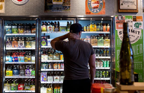 Ryan Youngdale stands in front of the beer fridge at Stinson Wine, Beer, and Spirits. ] COURTNEY PEDROZA ¥ courtney.pedroza@startribune.com July 2, 2