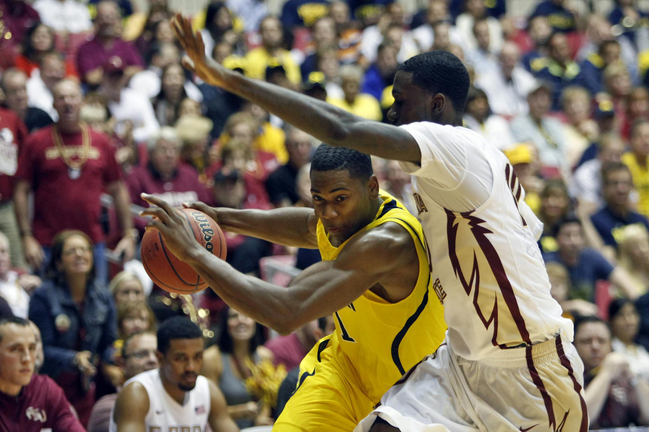 Florida State forward Okaro White, right, pressures Michigan forward Glenn Robinson during a NCAA college basketball game in San Juan, Puerto Rico, Friday, Nov. 22, 2013. (AP Photo/Ricardo Arduengo)