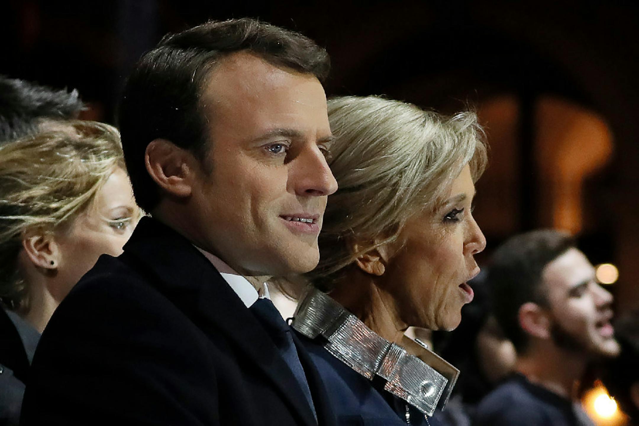 Incoming French President Emmanuel Macron and his wife Brigitte Macron sing the national anthem after he delivered a speech in front of the Pyramid at the Louvre Museum in Paris on Sunday.