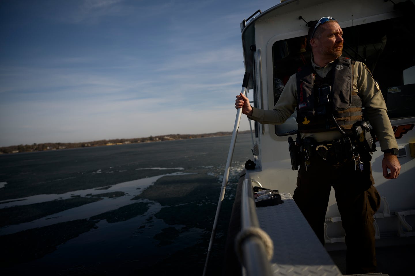 Hennepin County Sheriffs Sgt. Chad VanHeel looks on while using a pole to check the ice depth Monday, March 11, 2024 on Lake Minnetonka.