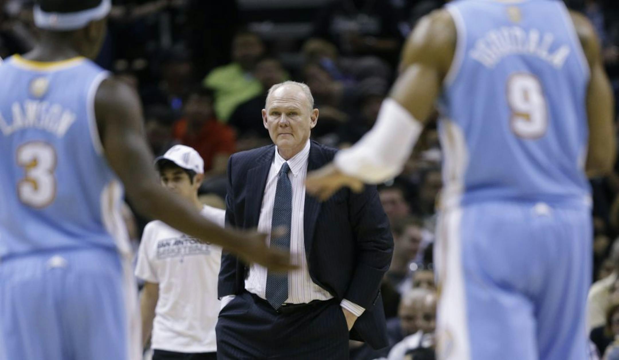 Denver Nuggets coach George Karl, center, waits for his team during a timeout in the second half of an NBA basketball game against the San Antonio Spurs, Wednesday, March 27, 2013, in San Antonio. San Antonio won 100-99.