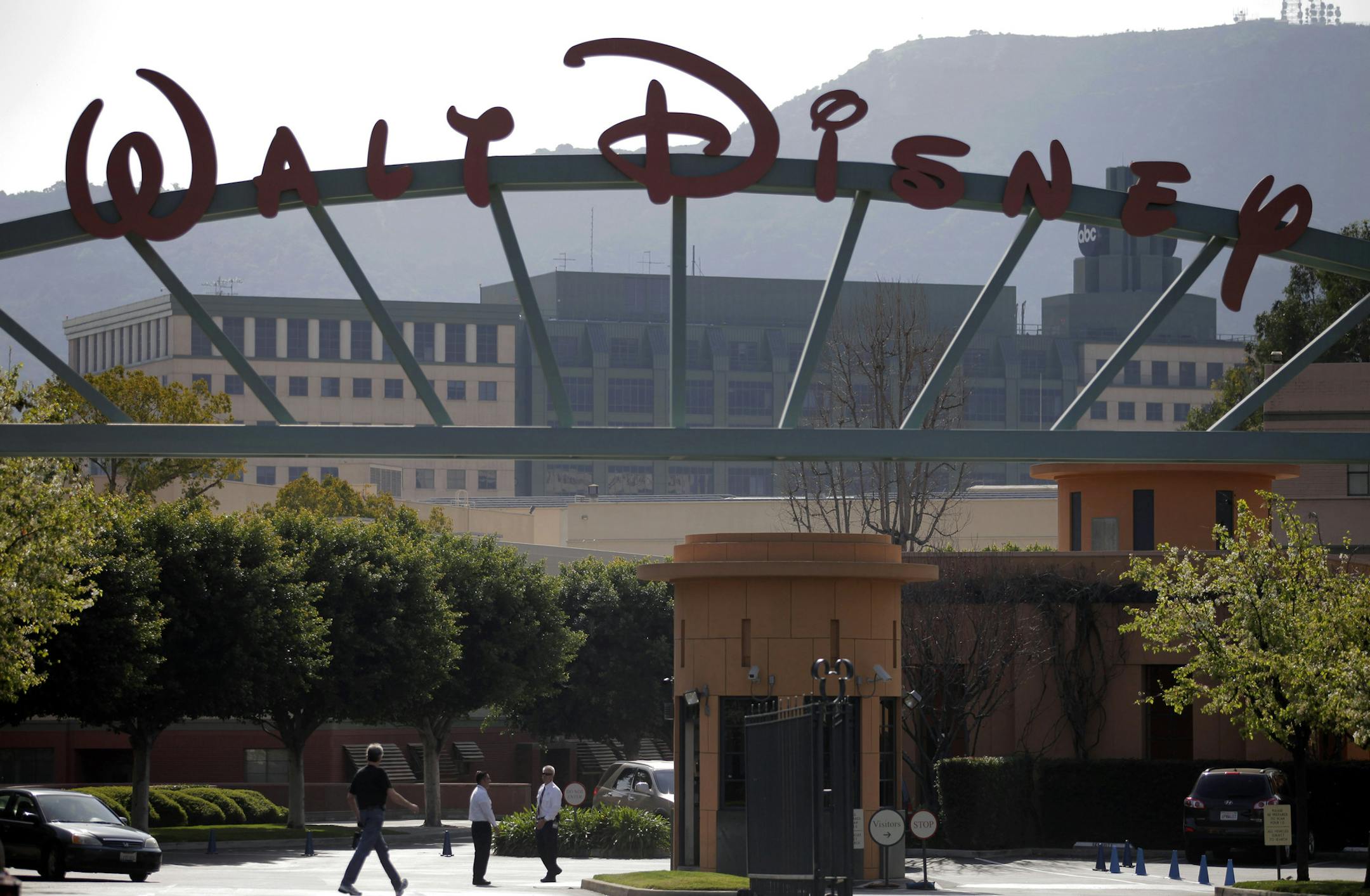 FILE - In this Feb. 8, 2011 file photo, people stand near the entrance to the Walt Disney Studios in Burbank , Calif. The Walt Disney Co. reports quarterly earnings on Thursday, Nov. 7, 2013. ( AP Photo/Jae C. Hong, File)