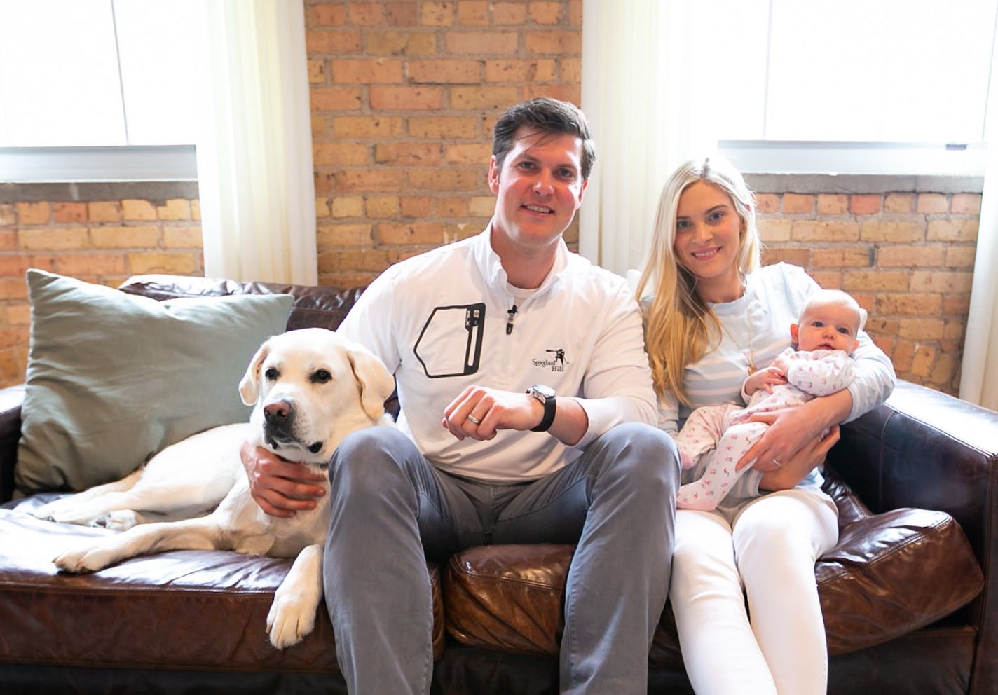 Kevin and Lauren McDermott in their Minneapolis condo with their daughter, Campbell, and their dog, Cash.