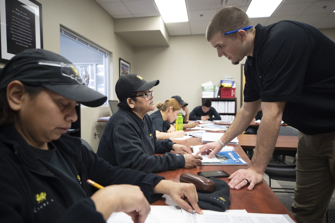 Christina Cuellar, center, received help from English teacher Ian Rude during class at Cambria. Noelia Sotelo was seated at left.