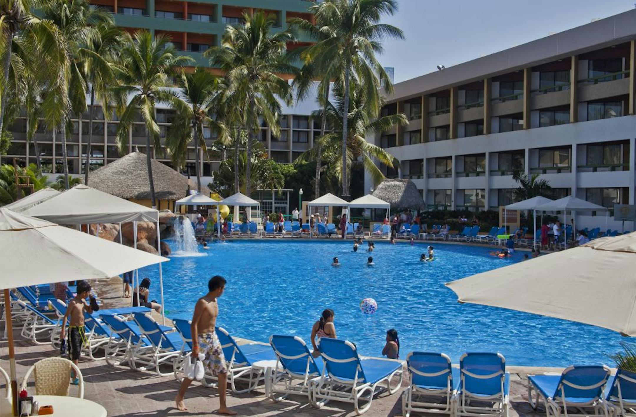 The oversized pool, with deck chairs and umbrellas, keeps kids busy, at the El Cid Castilla Hotel, Mazatlan, Mexico.