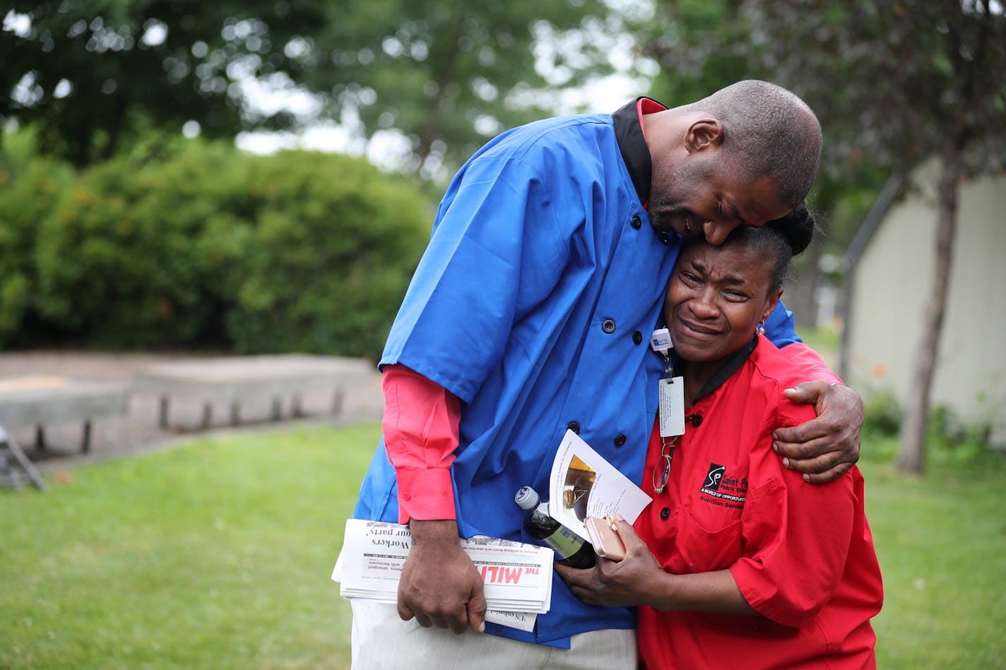 John Thompson, left, consoled Bolanle Allibalogun, both food service co-workers of Philando Castile's at the St. Paul School District.