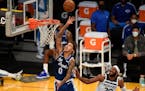 Los Angeles Lakers forward Kyle Kuzma, left, shoots past Minnesota Timberwolves guard Josh Okogie during the first half of an NBA basketball game in L