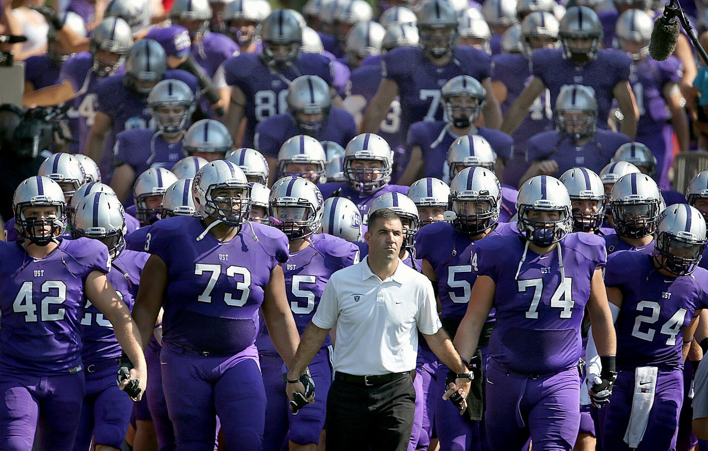 In this Sept. 27, 2014, file photo, St. Thomas coach Glen Caruso leads his team onto the field