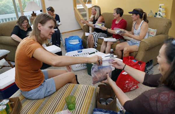 Marypat Habermas, front left, hosted a meal swap where 10 people exchanged frozen meals to help stock their freezers with a variety of dinners for up 