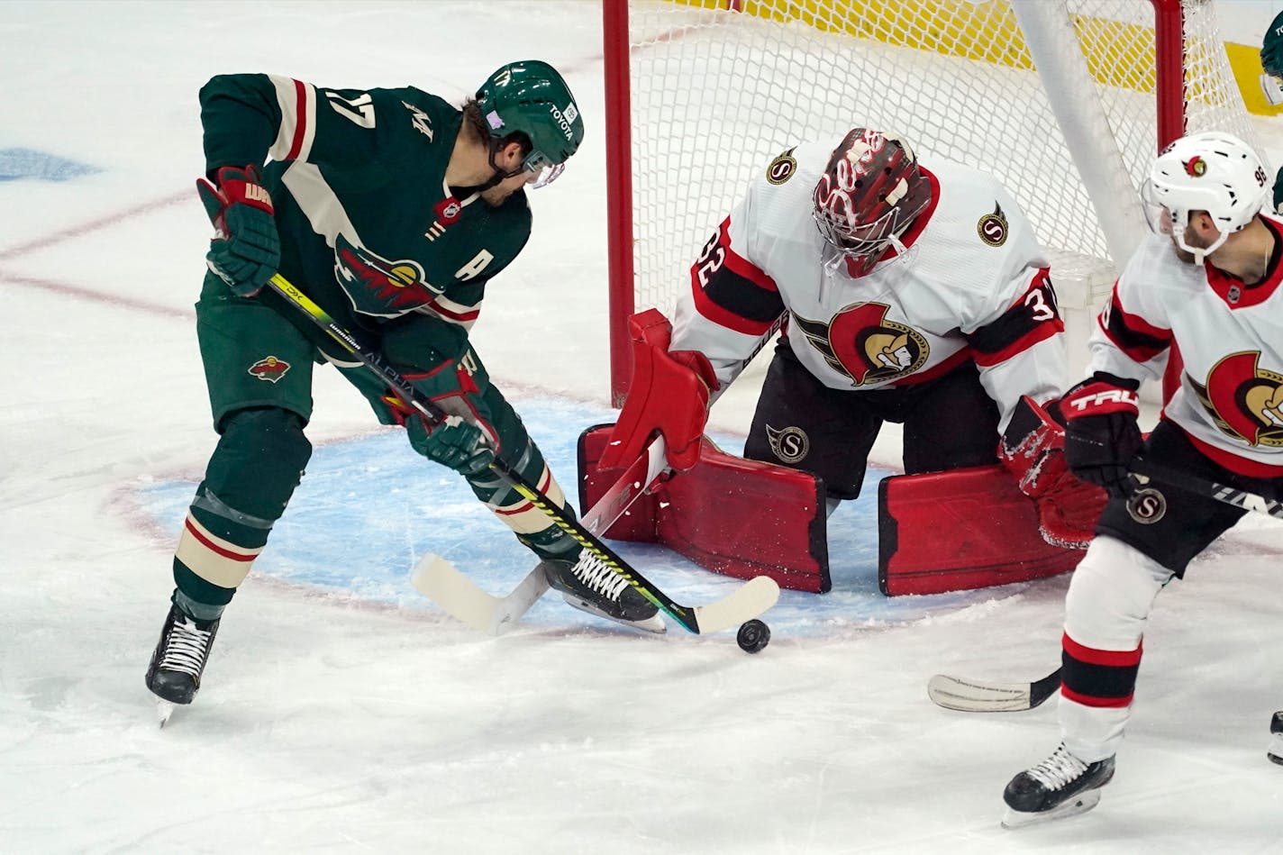 Ottawa Senators goalie Filip Gustavsson (32) makes a stop as Minnesota Wild's Marcus Foligno (17) works on a rebound moments before scoring a goal during the first period of an NHL hockey game Tuesday, Nov. 2, 2021, in St. Paul, Minn. (AP Photo/Jim Mone)