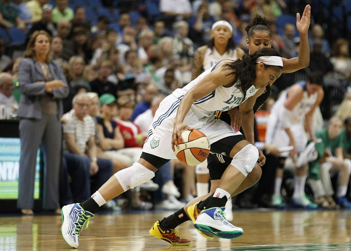 Minnesota Lynx guard Maya Moore, foreground, drives the ball past Tulsa Shock guard Angel Goodrich in the first half of a WNBA basketball game on Friday, Aug. 16, 2013, in Minneapolis.