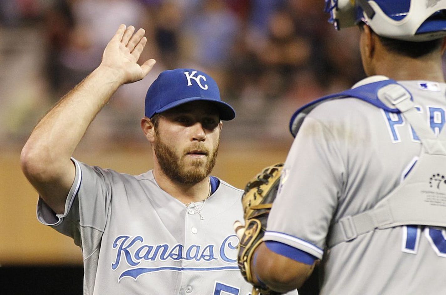 Kansas City Royals pitcher Greg Holland celebrates with teammate Salvador Perez after defeating the Minnesota Twins 4-3 in their baseball game in Minneapolis Wednesday, July 31, 2013.