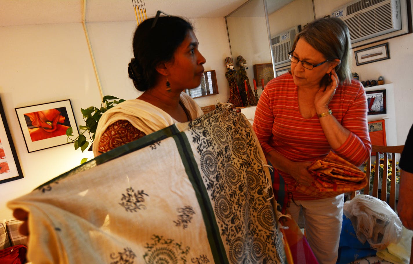 Sandhya Gupta, a former longtime Bloomington resident who now lives in India, showed some fabric to Karen Moore, of Hastings. Fabrics from India and other items will be sold at a silent auction during an upcoming Eagan fundraiser for Nari Gunjan, an organization that works with girls of the Dalit community (&#xec;the Untouchables&#xee;) of India. Photo by Liz Rolfsmeier, Special to the Star Tribune