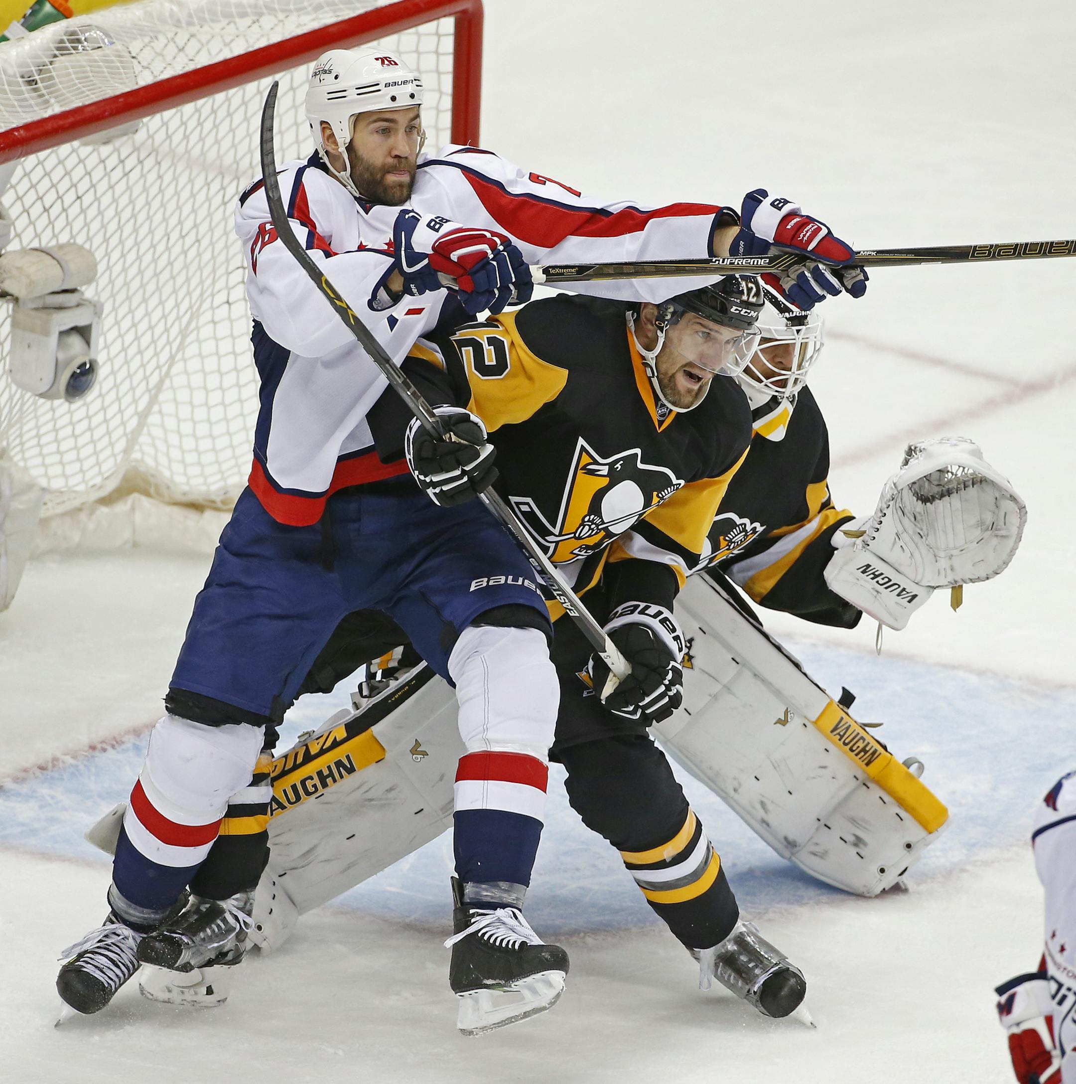 Washington Capitals Daniel Winnik (26) and Pittsburgh Penguins Ben Lovejoy (12) battle for position in front of the net while Pittsburgh Penguins goalie Matt Murray (30) looks fo the puck during the third period of Game 3 in an NHL hockey Stanley Cup Eastern Conference semifinals in Pittsburgh, Monday, May 2, 2016. (AP Photo/Gene J. Puskar)