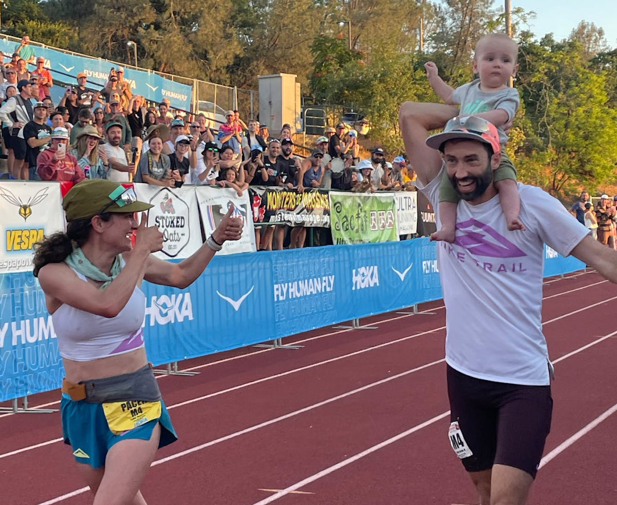 Tyler Green carried his son, Lewis, at the finish of his Western States 100 on Saturday. Celebrating with them was his wife, Rachel Drake, left.